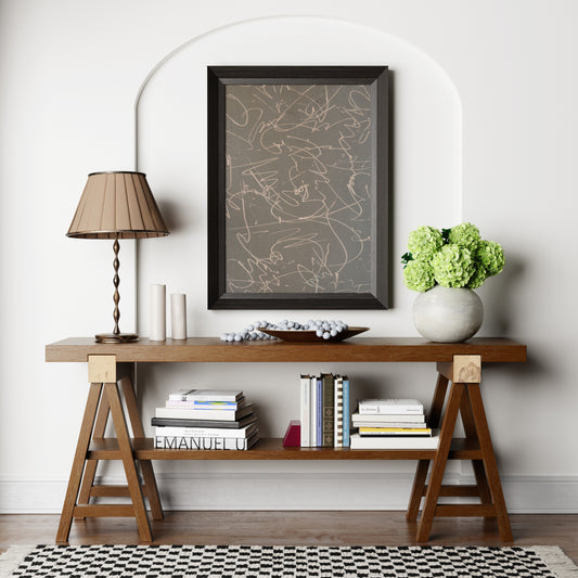 Monochrome abstract art print above a wood sideboard.