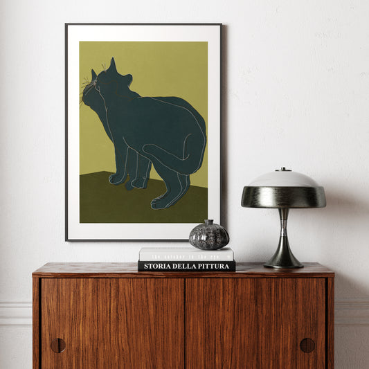 Art print with a cat, above a vintage wood sideboard.
