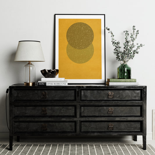 Yellow geometric abstract art print on a black sideboard.