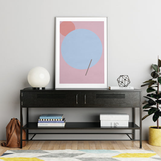 Pink graphic art print with a blue circle, in a modern interior.