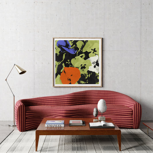 Framed pop art print with flowers, above a red sofa in a modern interior.