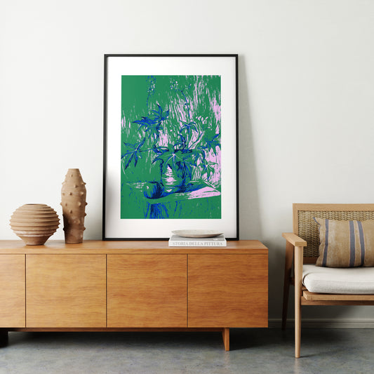 Still life with plant, green graphic art print in a natural interior.