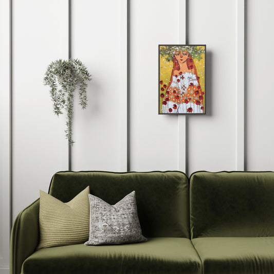 Green sofa with decorative pillows against a white paneled wall with a framed artwork.