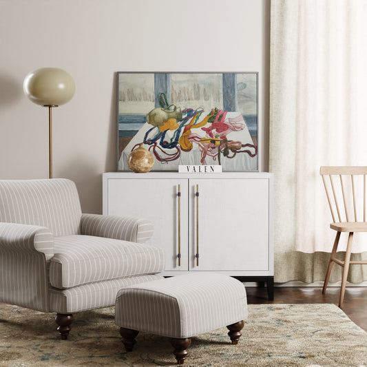 Figurative art print with colored threads in a living room with striped armchair, ottoman and white cabinet.