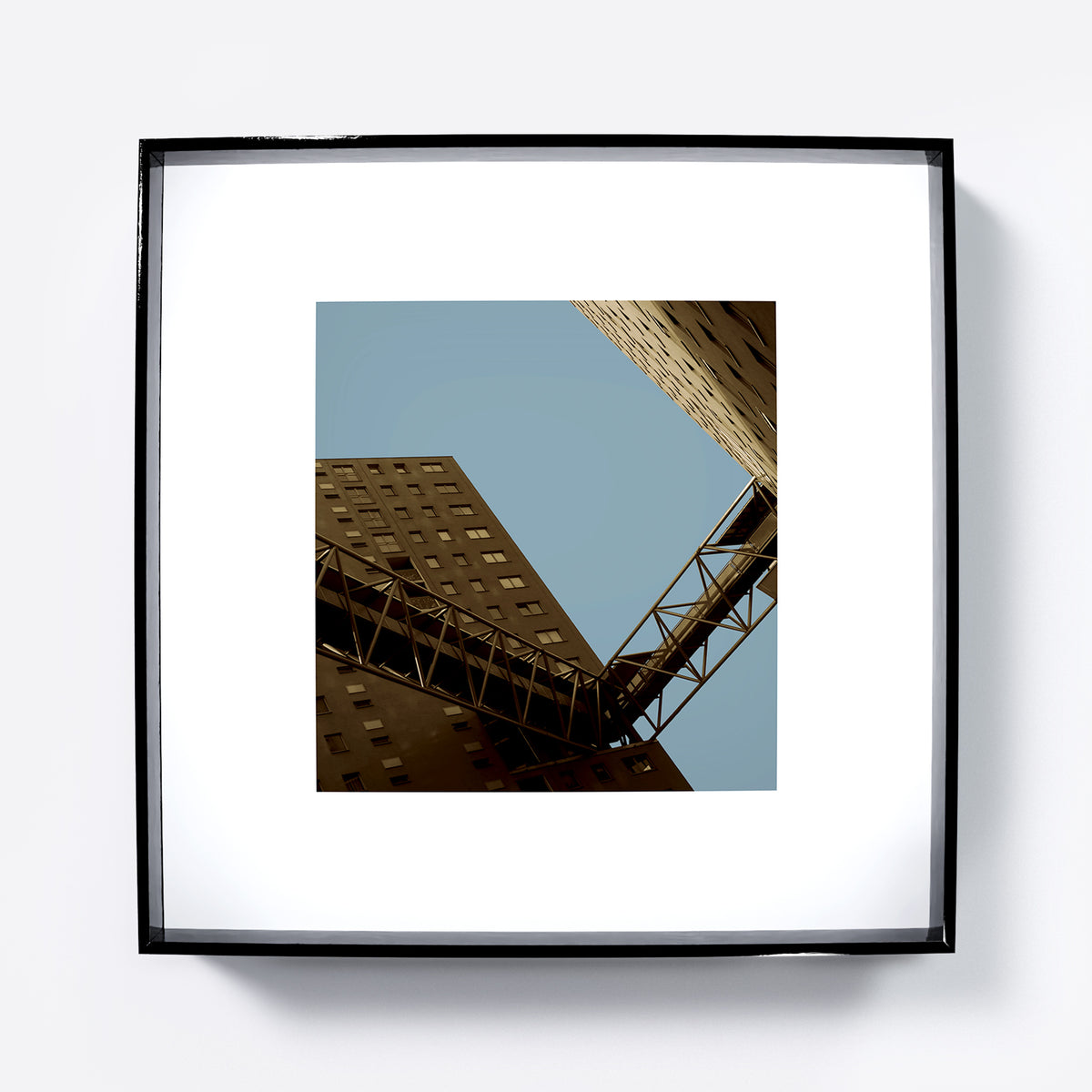 Urban photography art print with apartment blocks in perspective on a flat blue sky.
