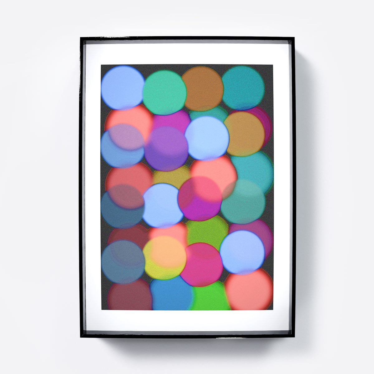 Framed abstract art with colorful circles on a black background.