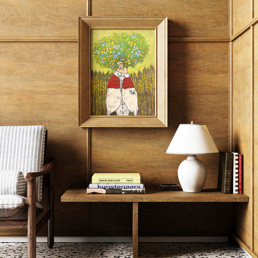 Framed artwork on a wooden wall above a shelf with books and a lamp.