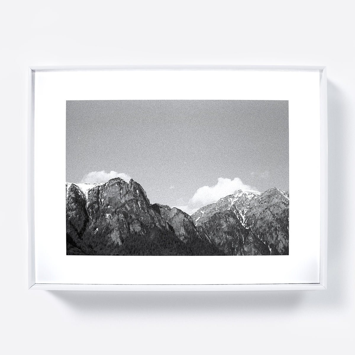 Black and white photograph of mountain landscape in a white frame.