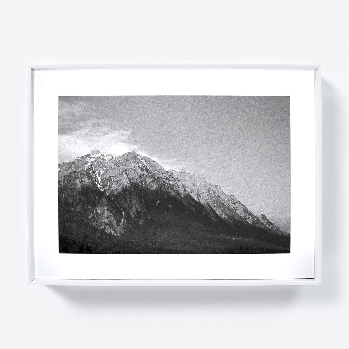 Framed black and white photograph of a mountain range with snow-capped peaks.