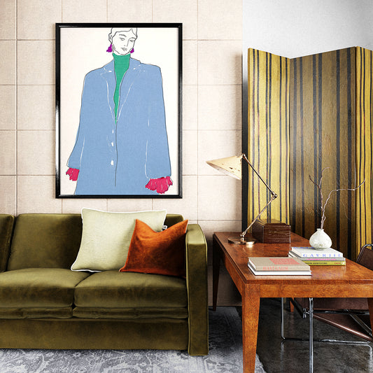 Modern living room with a green sofa, wooden desk, and fashion illustration print on the wall.