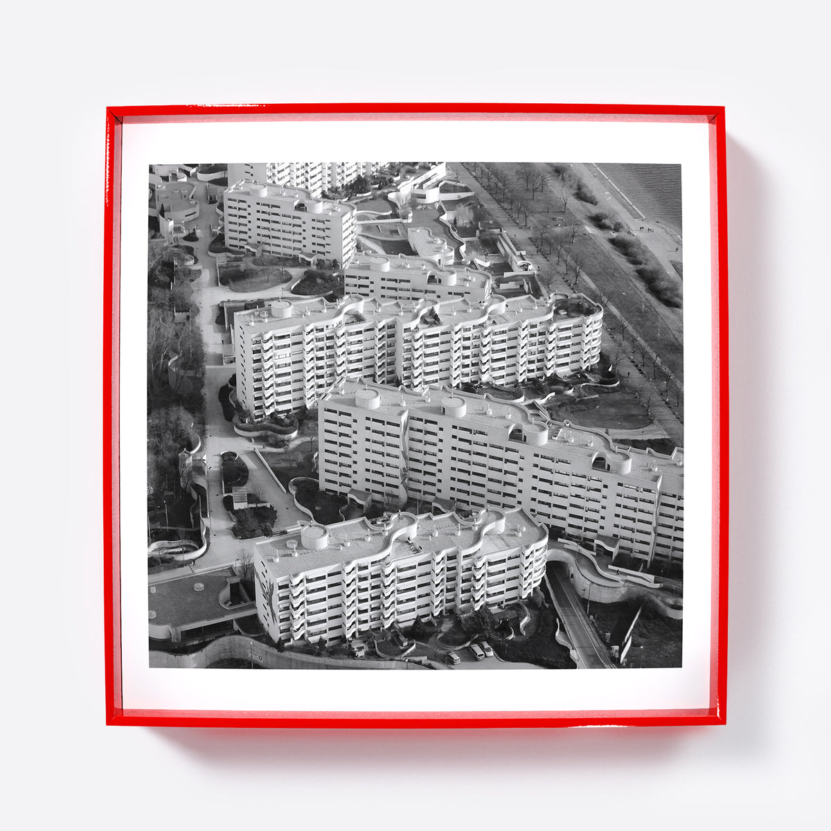 Art print depicting an aerial view of a residential area with apartment buildings in a red frame.