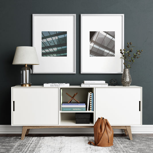 Two modern architectural photography art prints on a dark green wall.