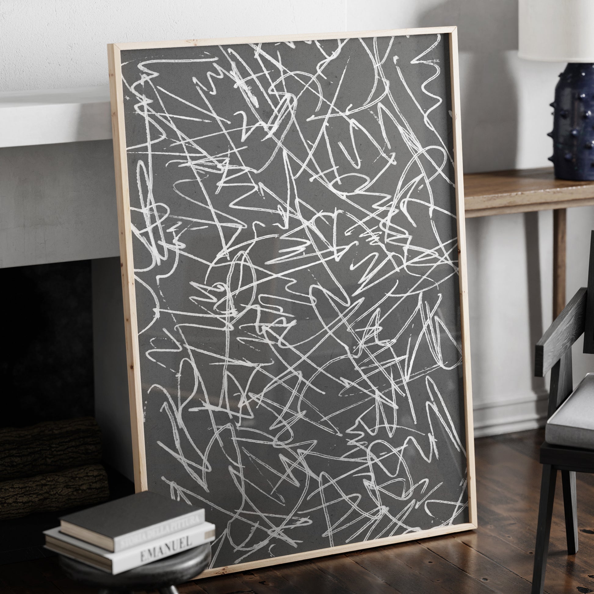 Black and white abstract art print in a natural wood frame.