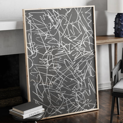 Black and white abstract art print in a natural wood frame.
