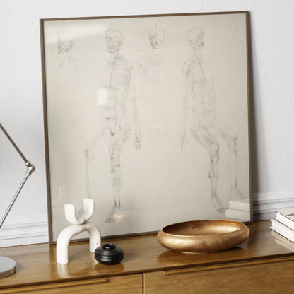 Monochrome anatomy art print with seated figures, on a wood sideboard.