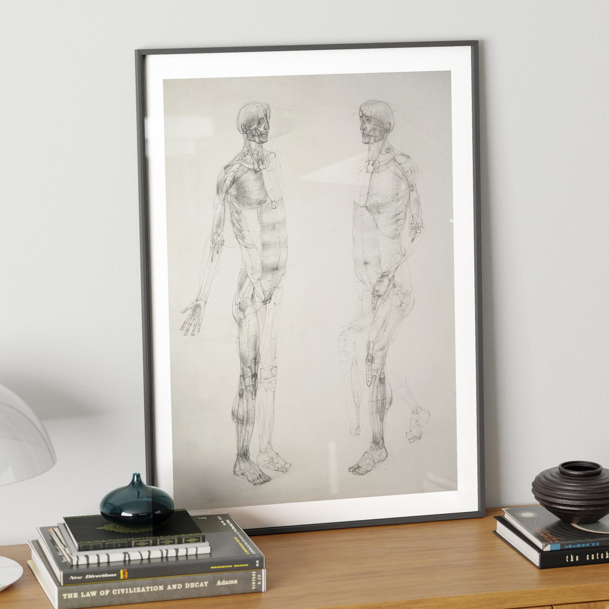 Monochrome human body anatomy art print on a sideboard.