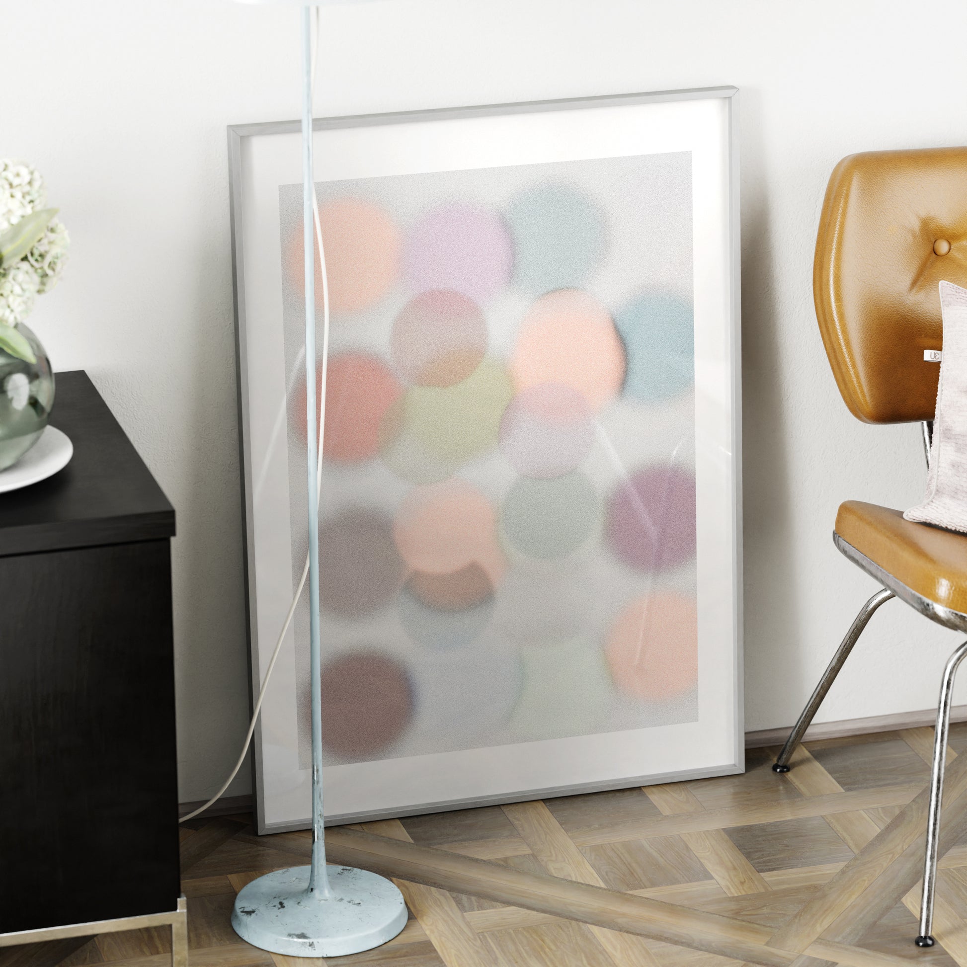 Framed abstract artwork with colorful circles in a modern room setting.
