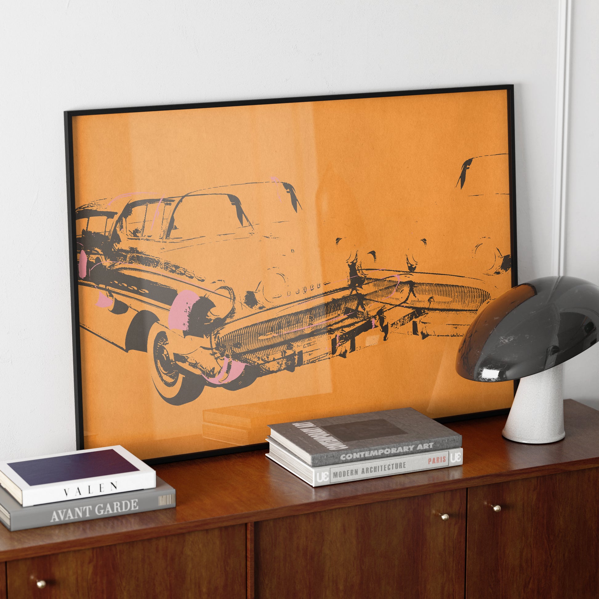 Orange car crash pop art art print on a mid-century modern sideboard.