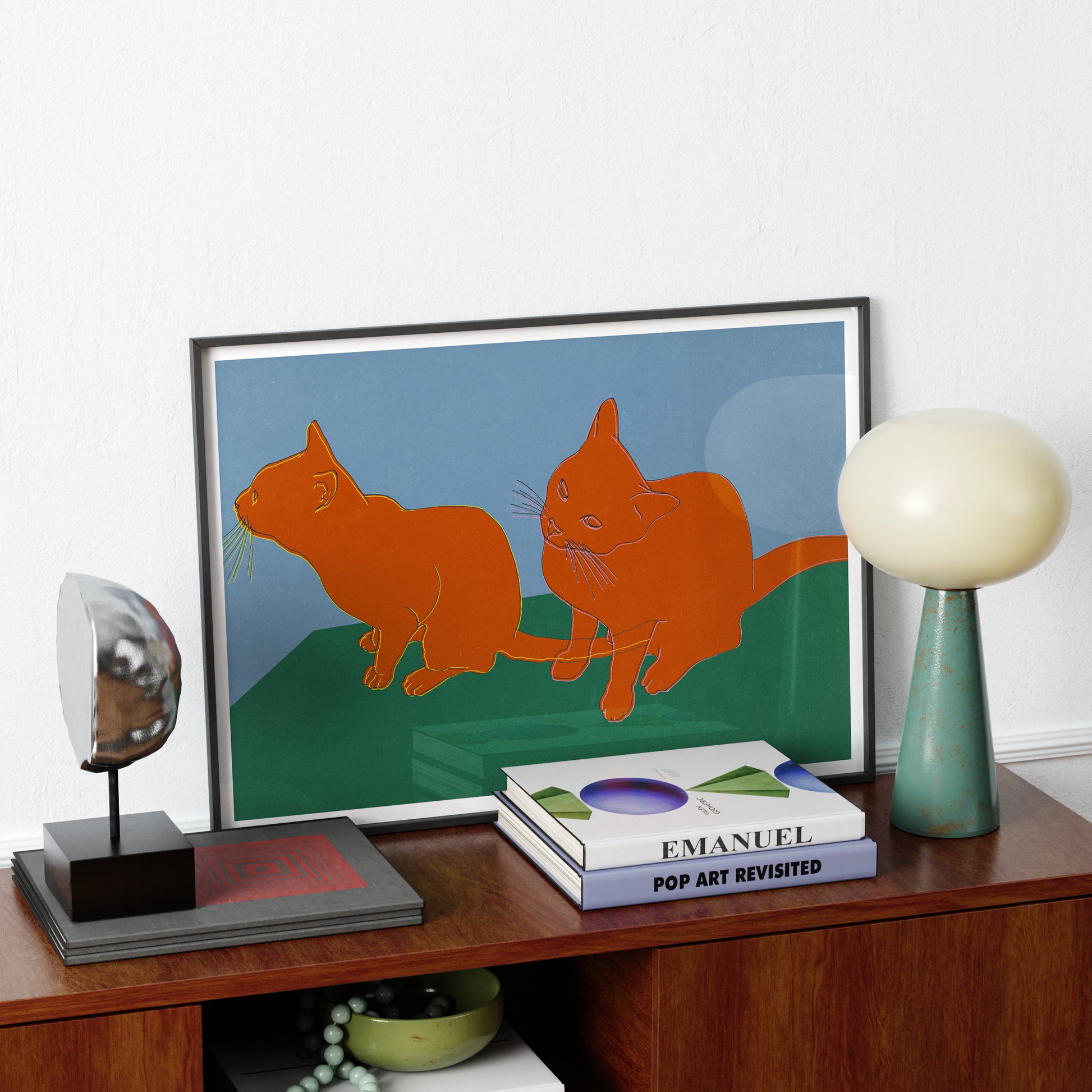 Art print with cats on a wood sideboard.