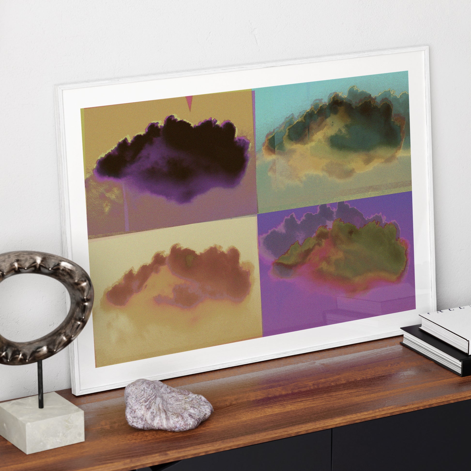 Colorful pop art print with clouds, in a white frame on a modern sideboard.