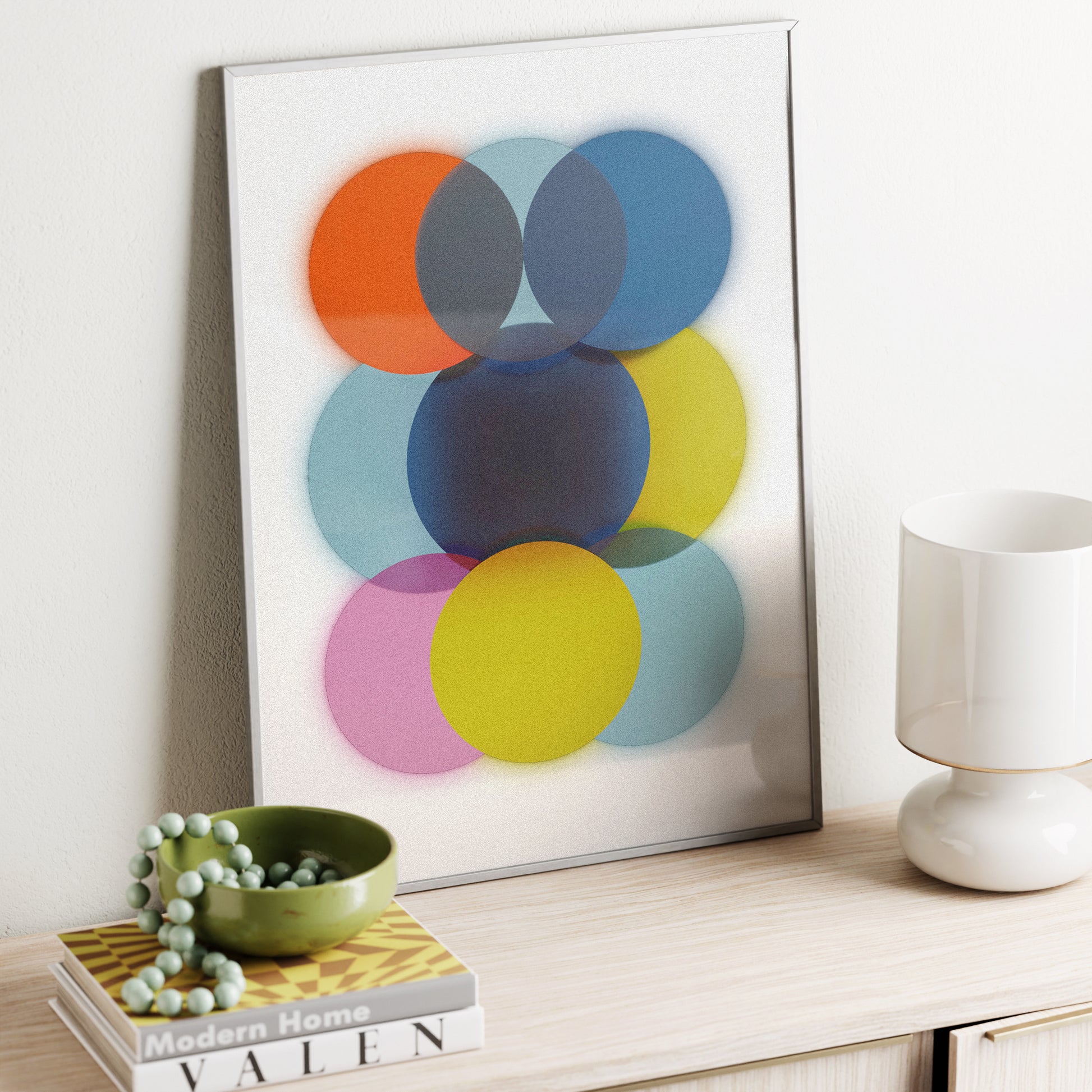 Colorful abstract art print on a wall above a shelf with decor items.
