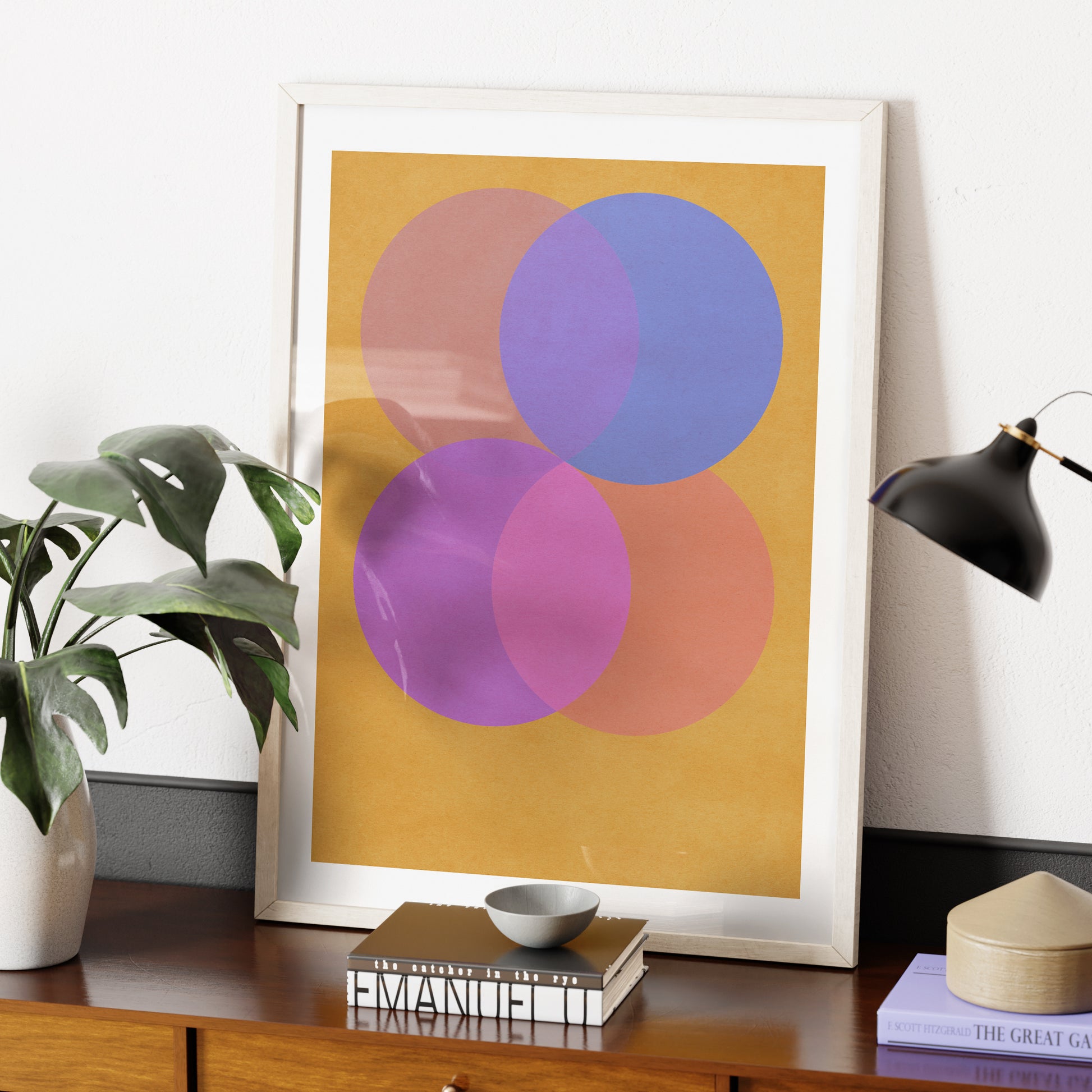 Colorful geometric graphic art print on a wood sideboard.