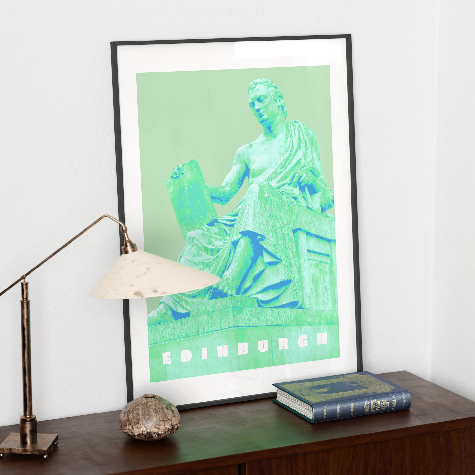 Travel poster Edinburgh landmark green art print on a dark wood sideboard.
