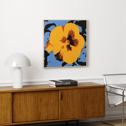 Pop art canvas print with big yellow flower, above a wood sideboard.