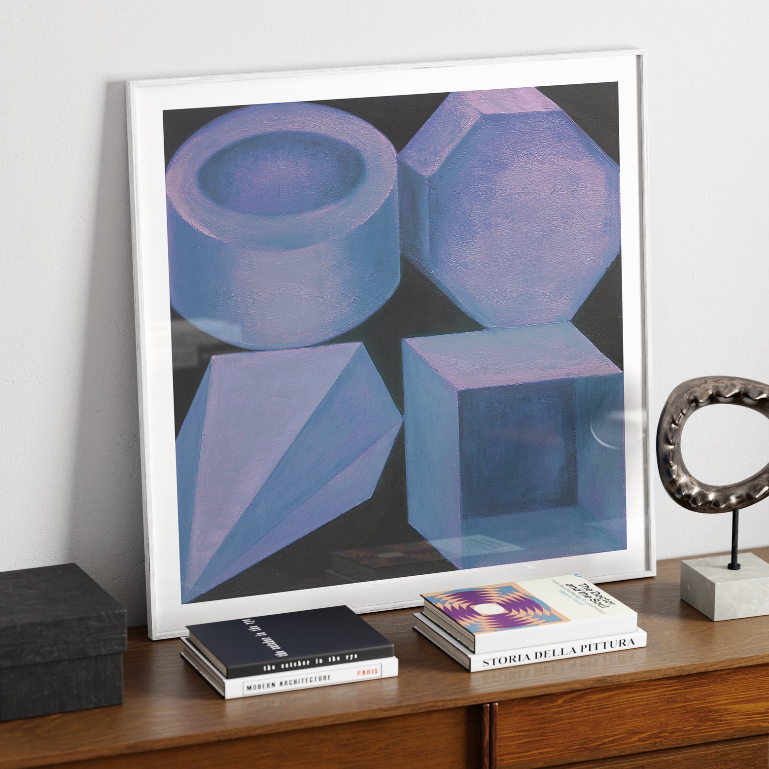 Blue geometric shapes on a black background art print, on a sideboard.