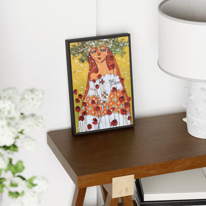 Framed artwork of a woman with red hair and flowers on a wooden surface.