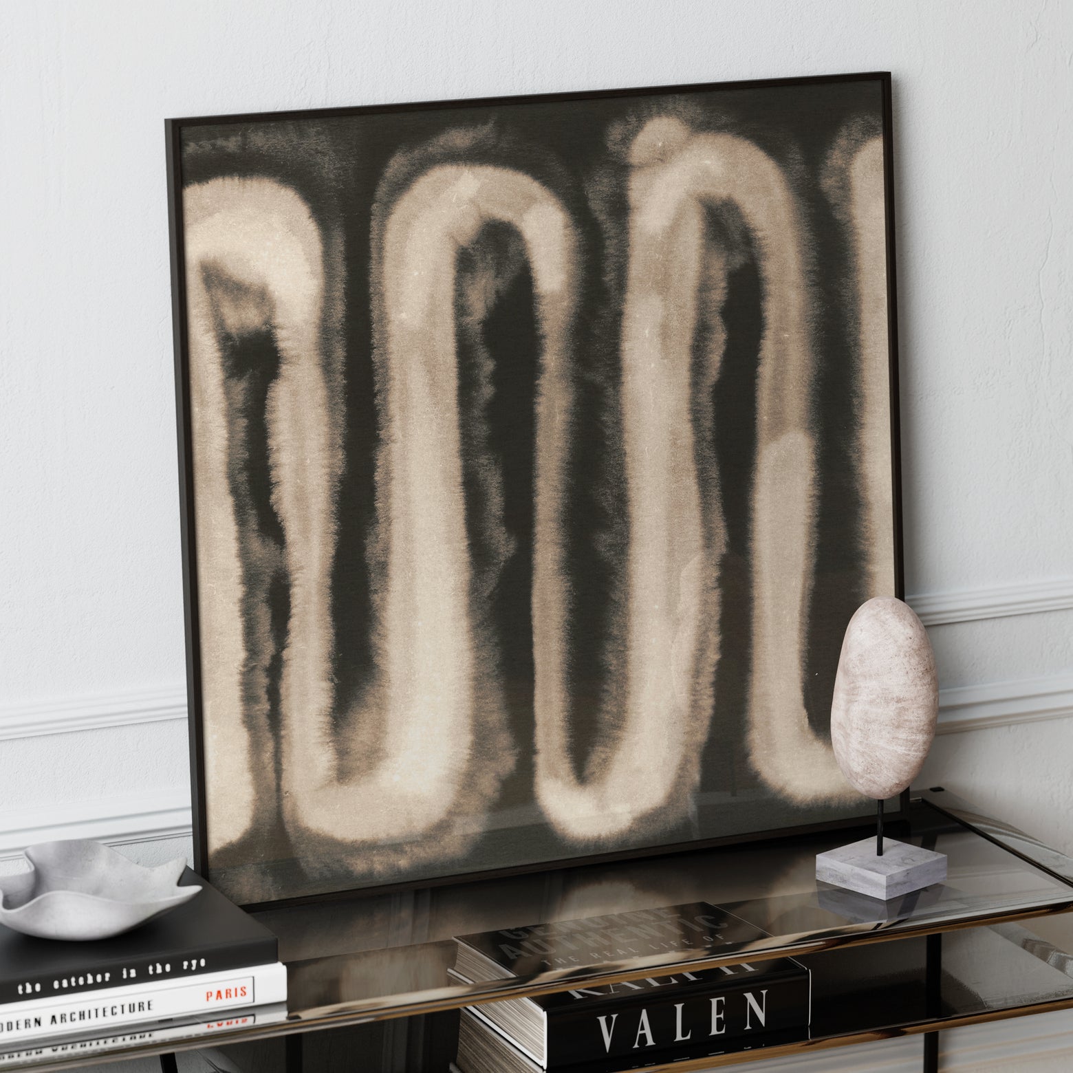 Monochrome watercolor abstract art print on a glass sideboard.