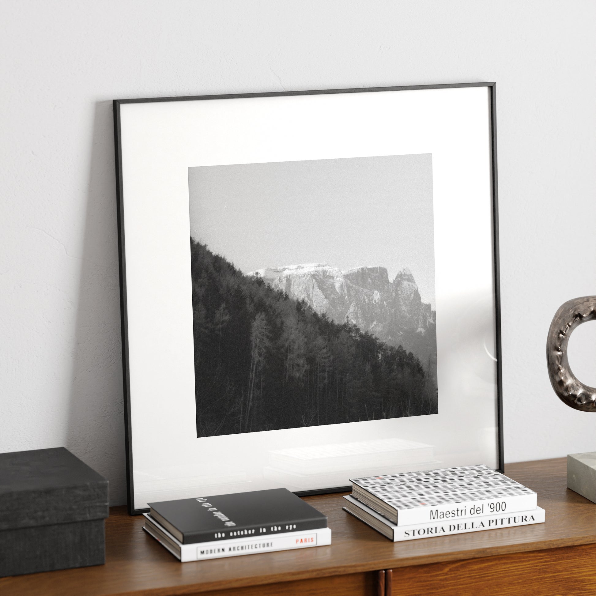 Moody mountains landscape photography, black and white art print on a sideboard.
