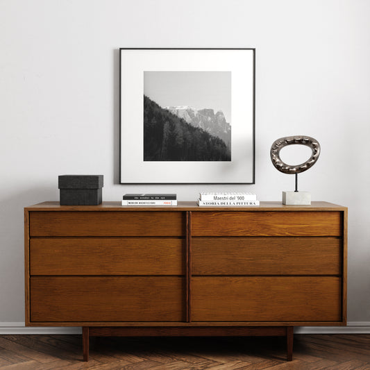 Moody mountains landscape photography, black and white art print above a solid wood vintage sideboard.