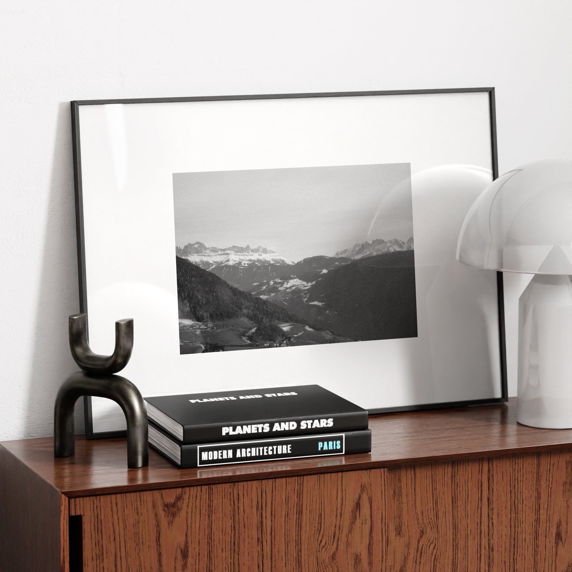 Mountain landscape black and white vintage photography art print on a wood sideboard.