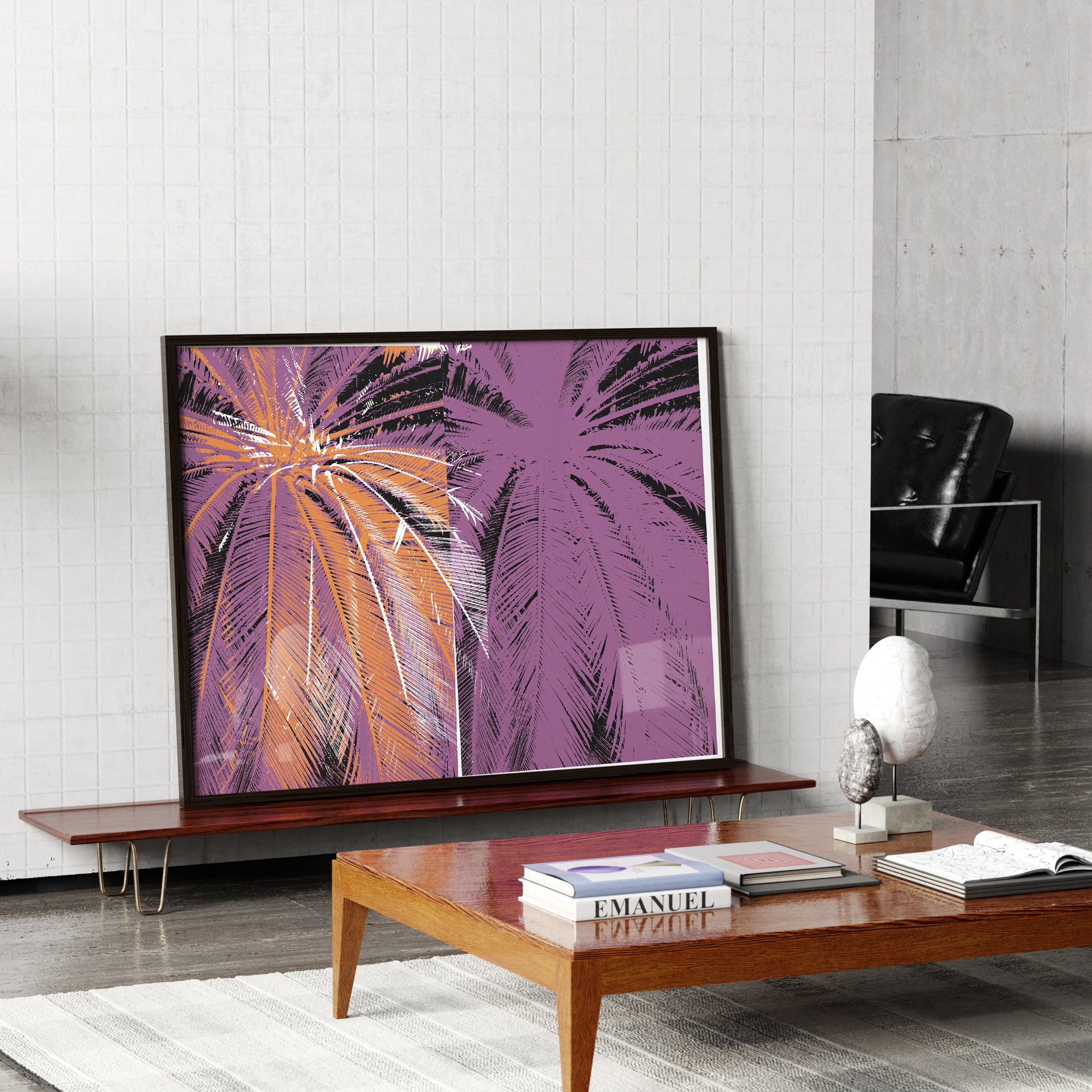 Modern living room with a large Pop art print with palm trees, a wooden coffee table with books, and a black chair.