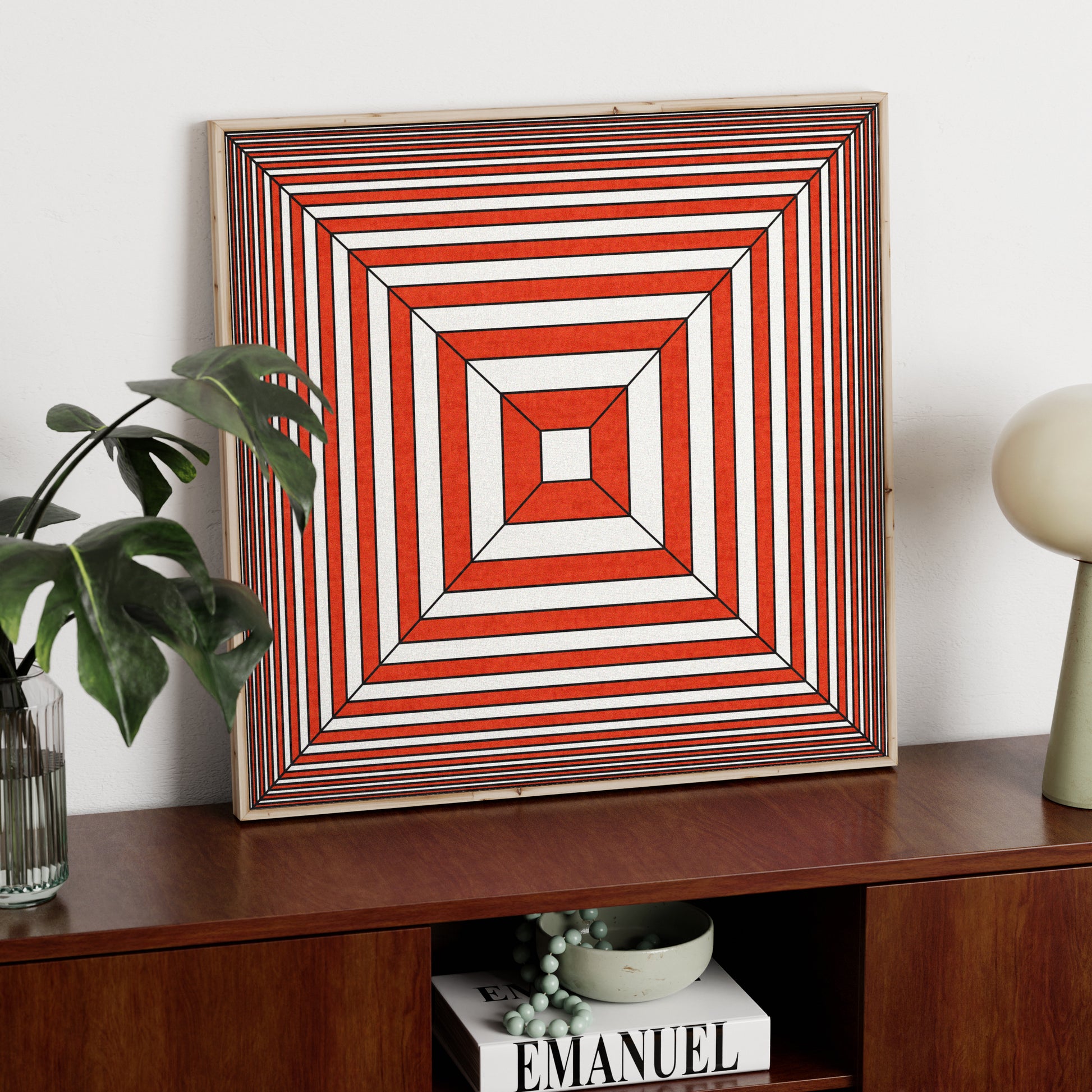 Red and white geometric abstract graphic art print on a sideboard.