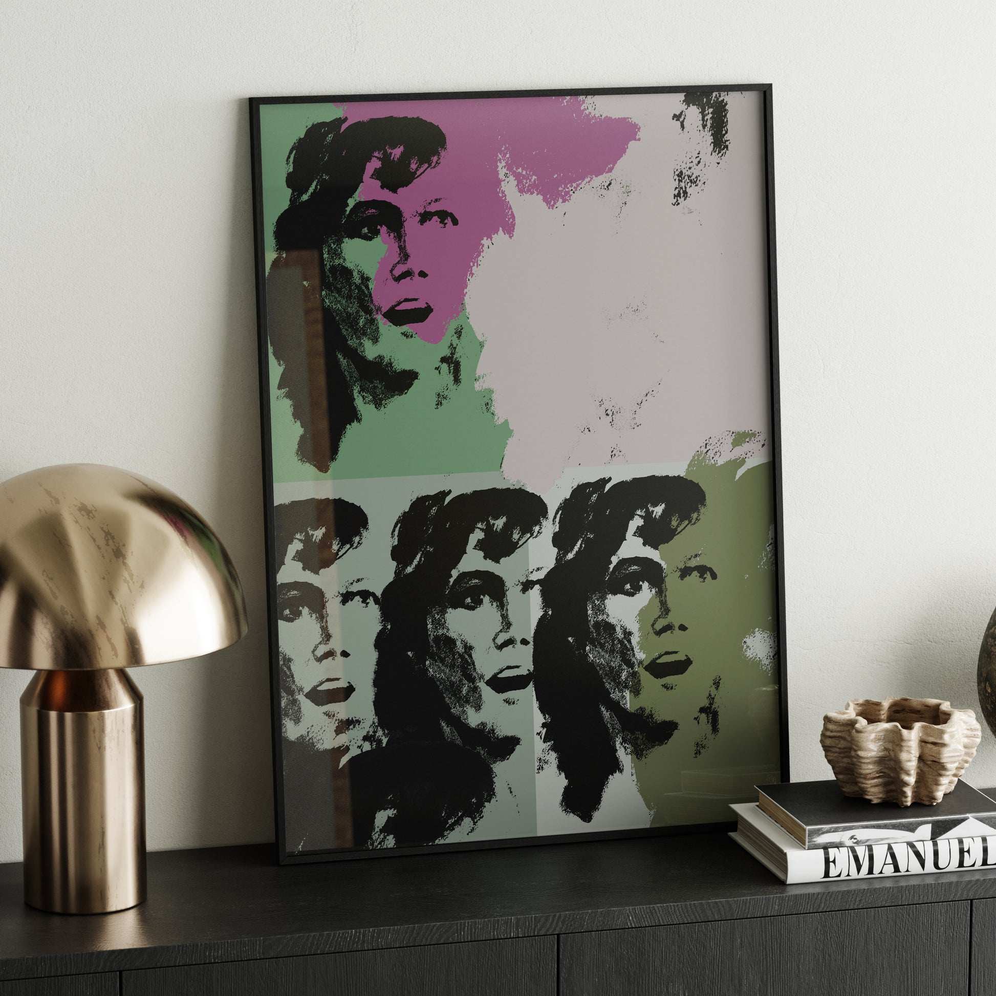 Green and pink pop art art print on a dark wood sideboard.