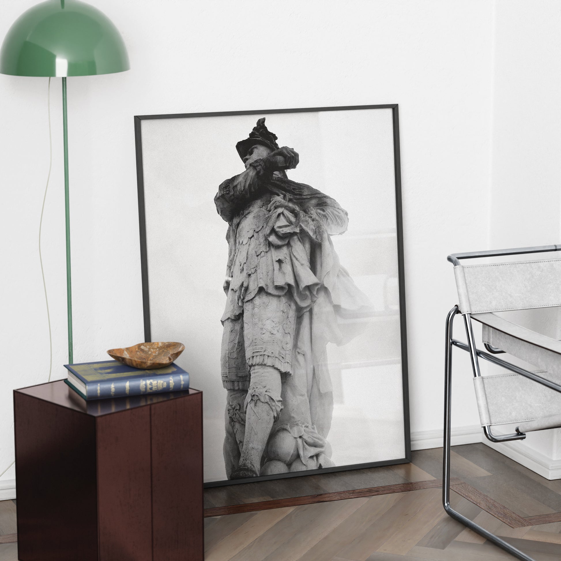 Framed black and white photography art print on a wall in a room with a lamp and chair.