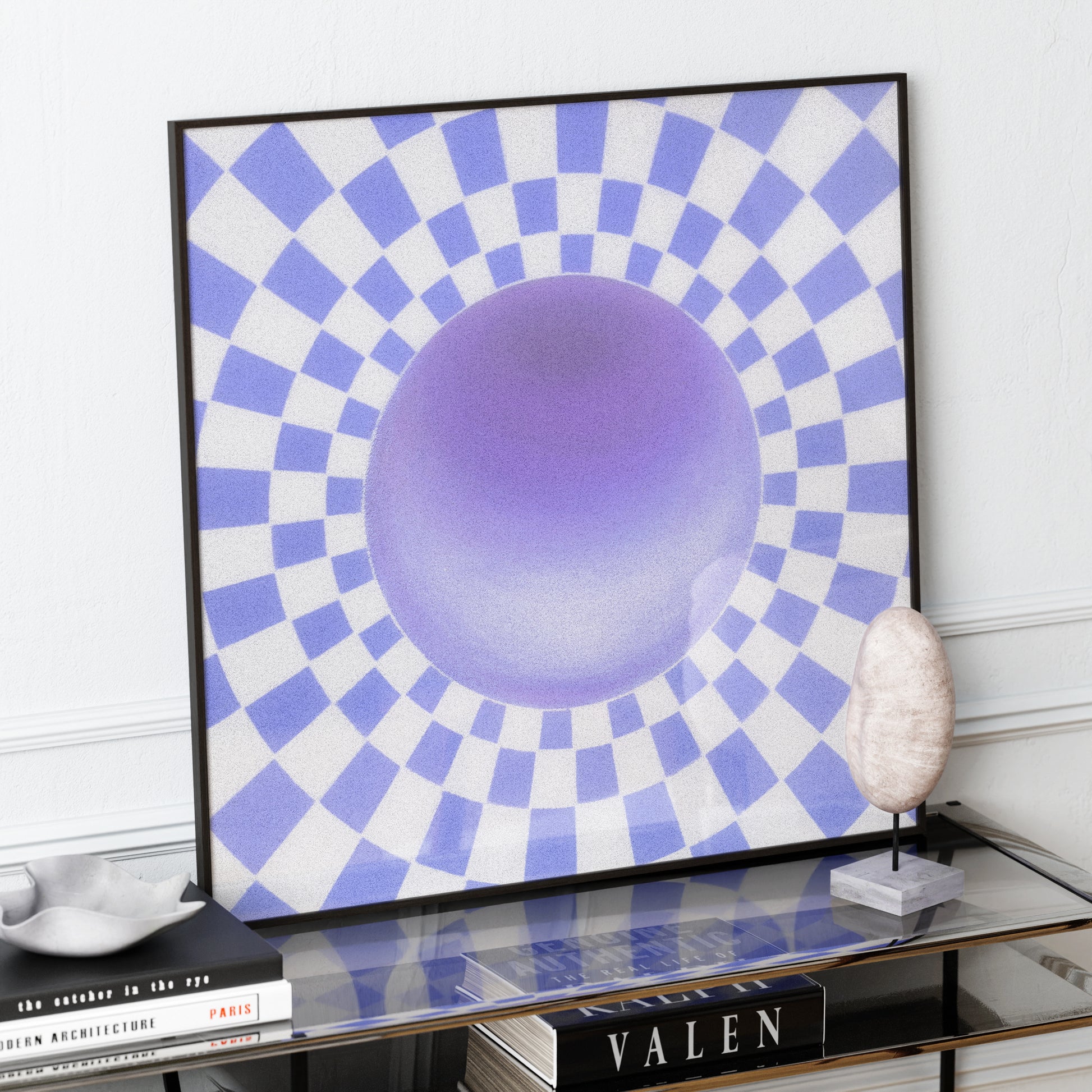 Framed abstract artwork with blue and purple circle design on a white wall.