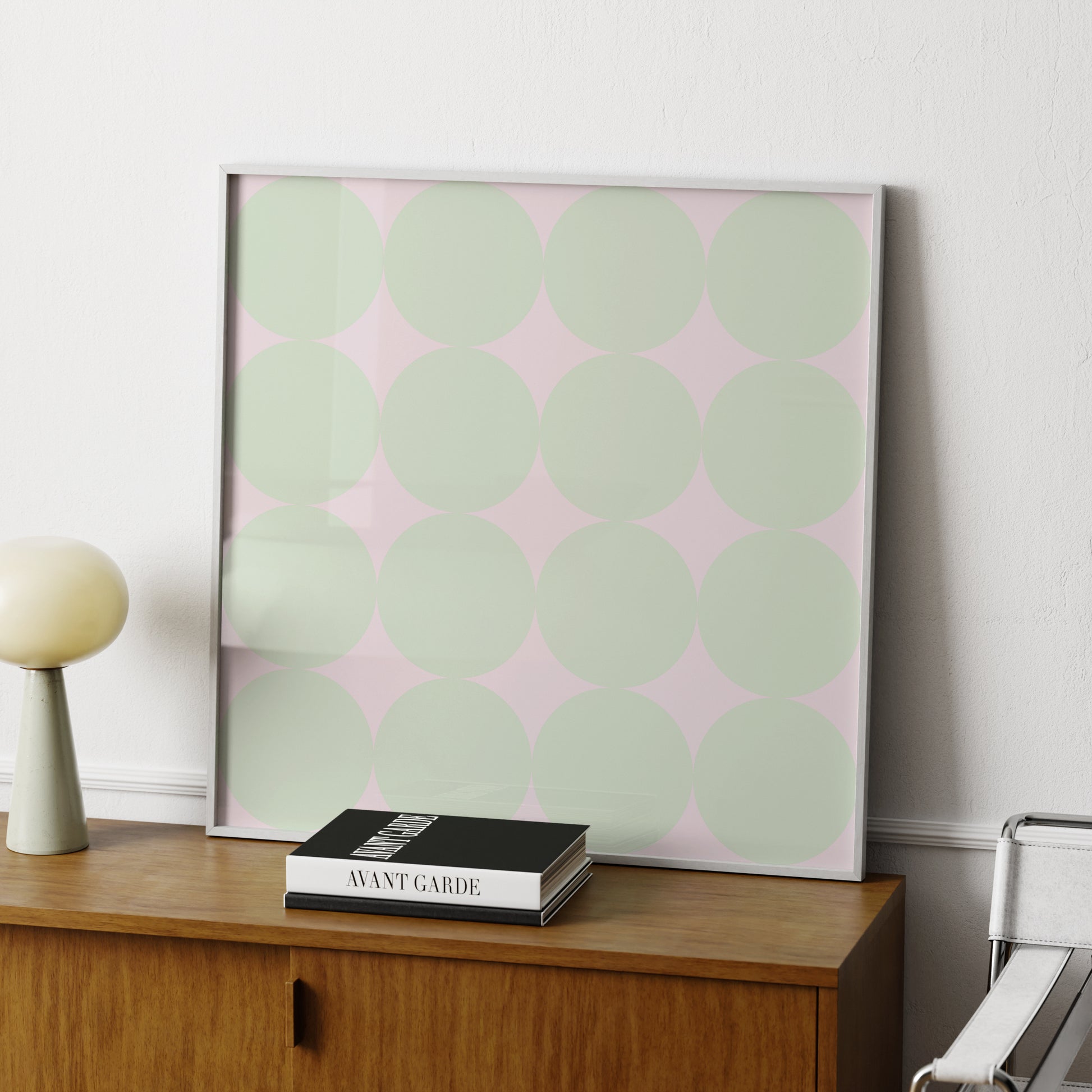 Green dots on a pink background, minimalist contemporary art print on a wood sideboard.