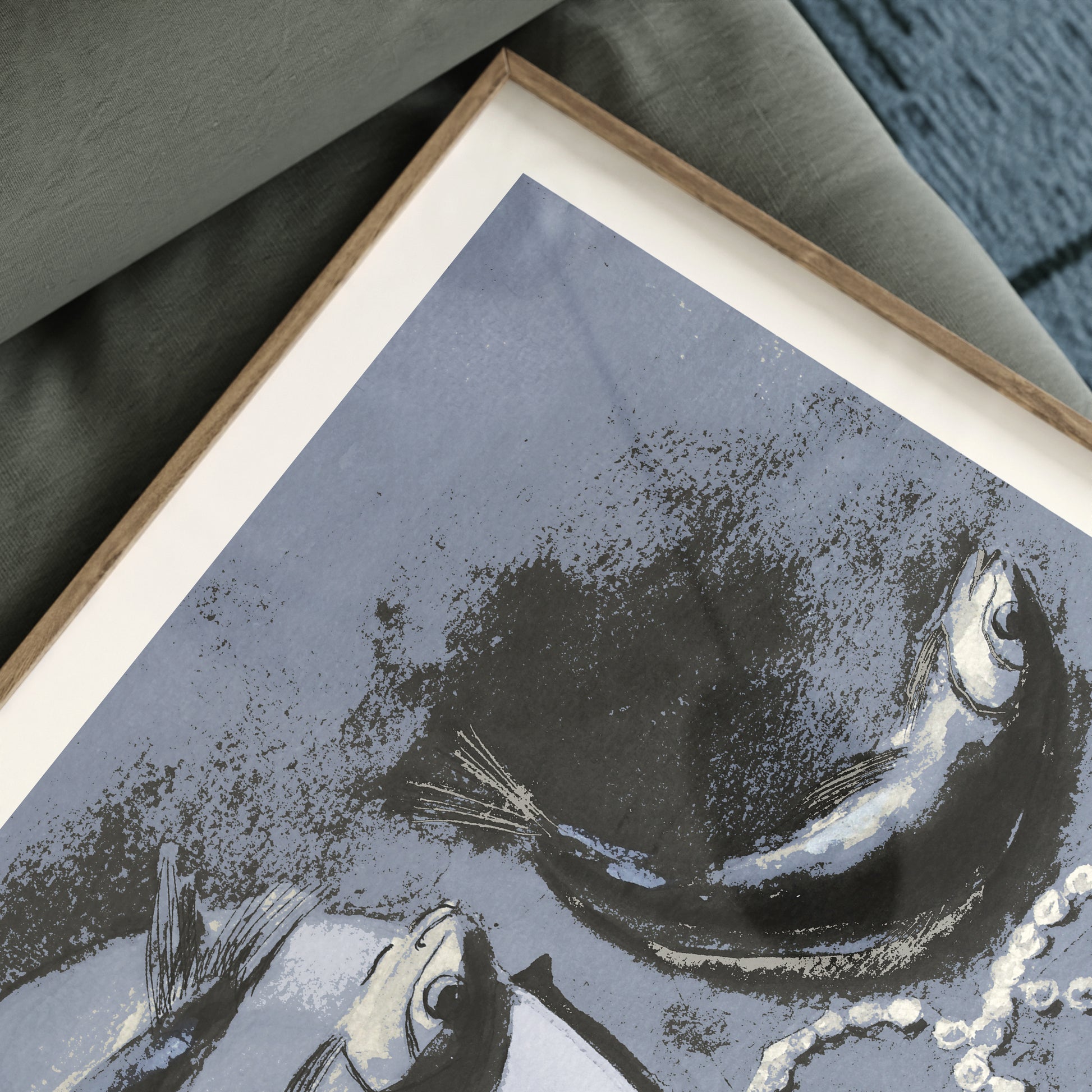 Detail of a framed art print with fish on a textured blue background.