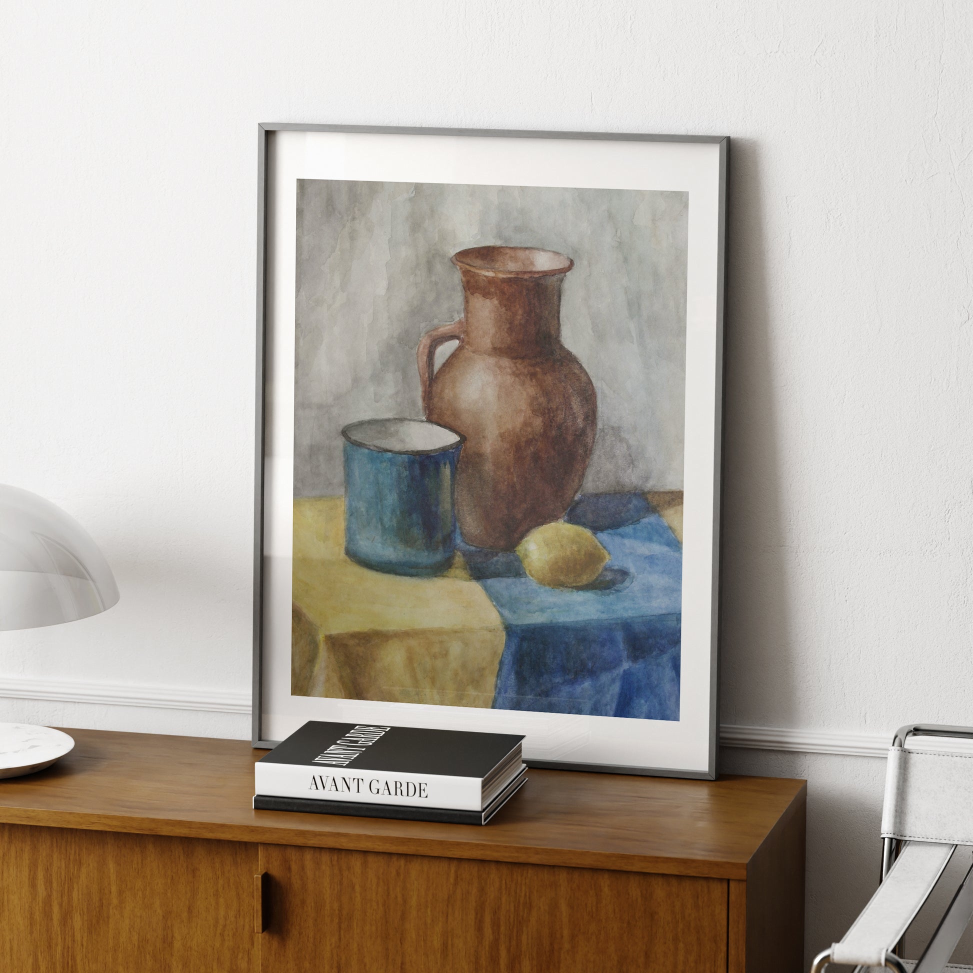 Watercolor still life study with lemon, naive art print, on a wood sideboard.
