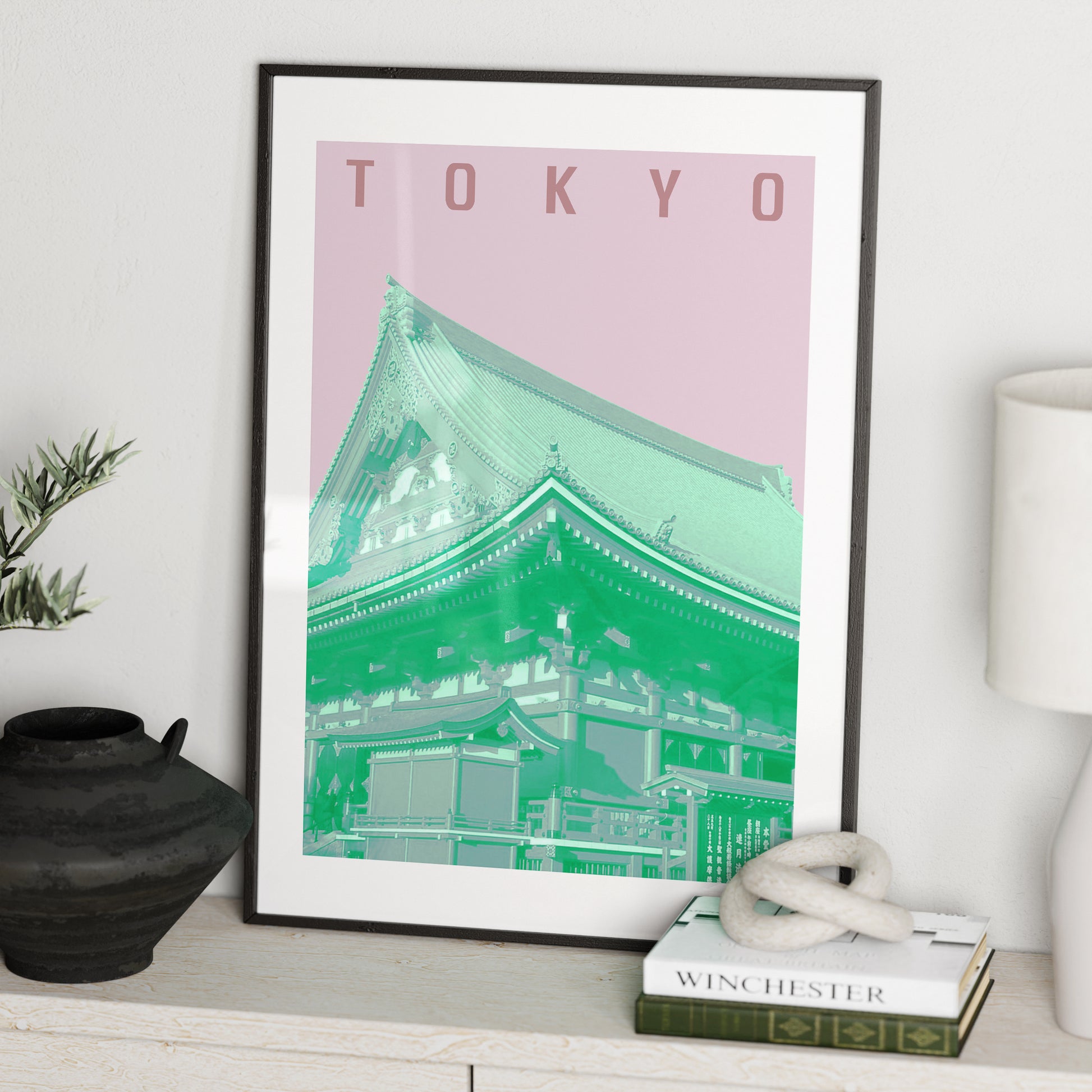 Travel poster Tokyo landmark, green and pink art print on a white sideboard.