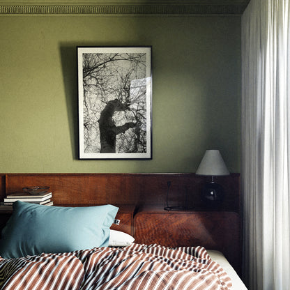 Bedroom with wooden headboard, striped bedding, and framed artwork on green wall.