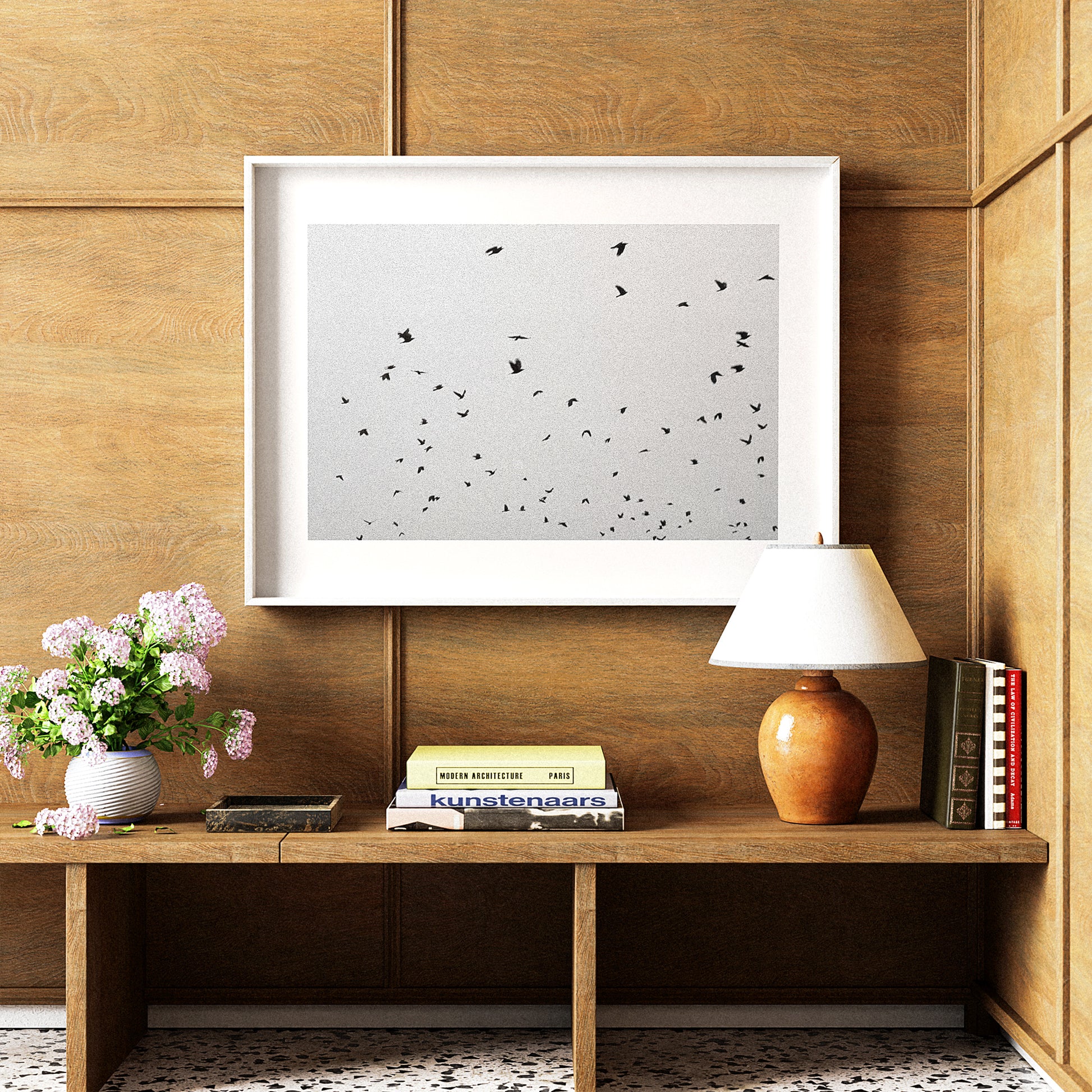 Wooden shelf with a lamp, books, and a framed picture on a wooden wall.