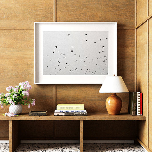 Wooden shelf with a lamp, books, and a framed picture on a wooden wall.
