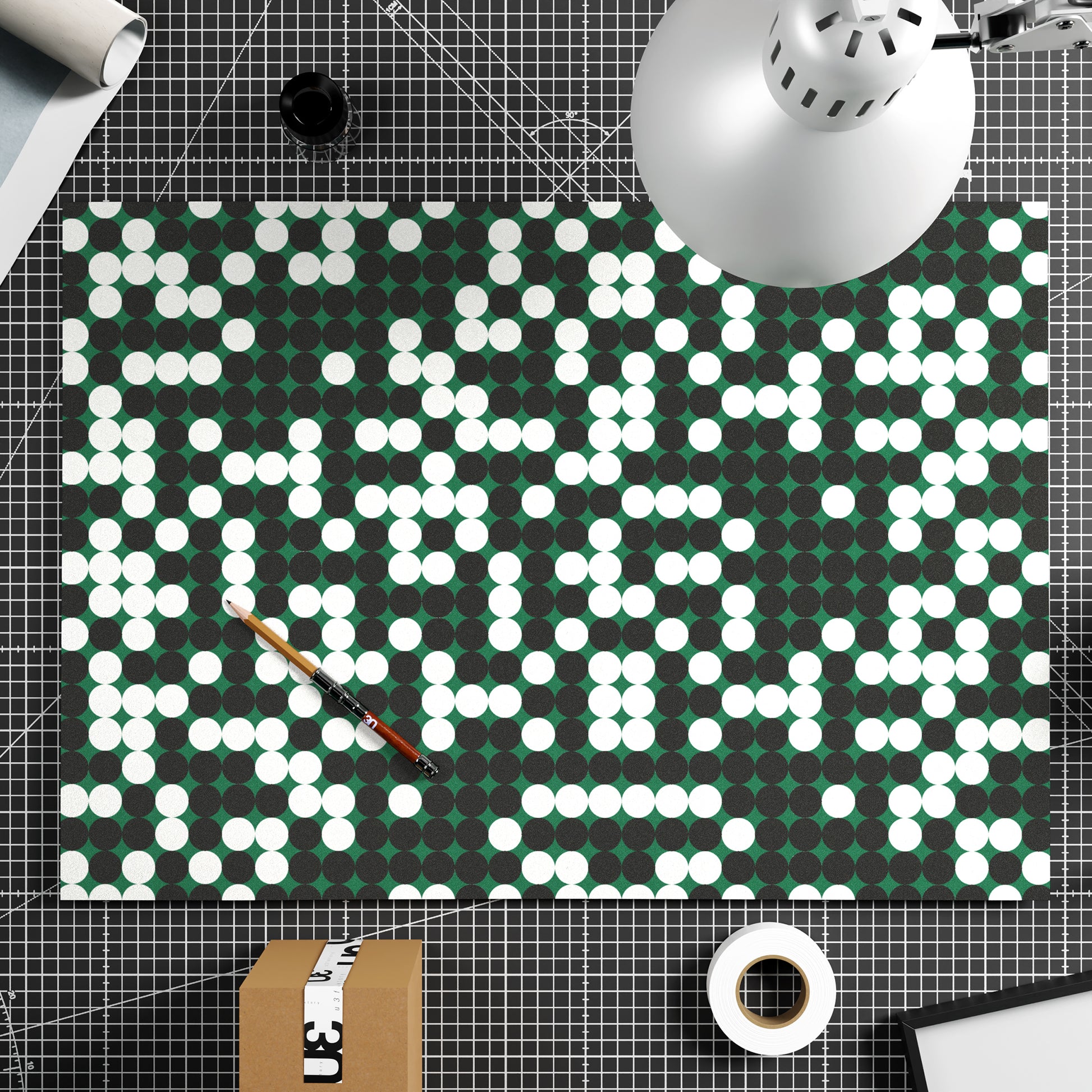 Pattern design art print on paper with white and black dots on a green background.