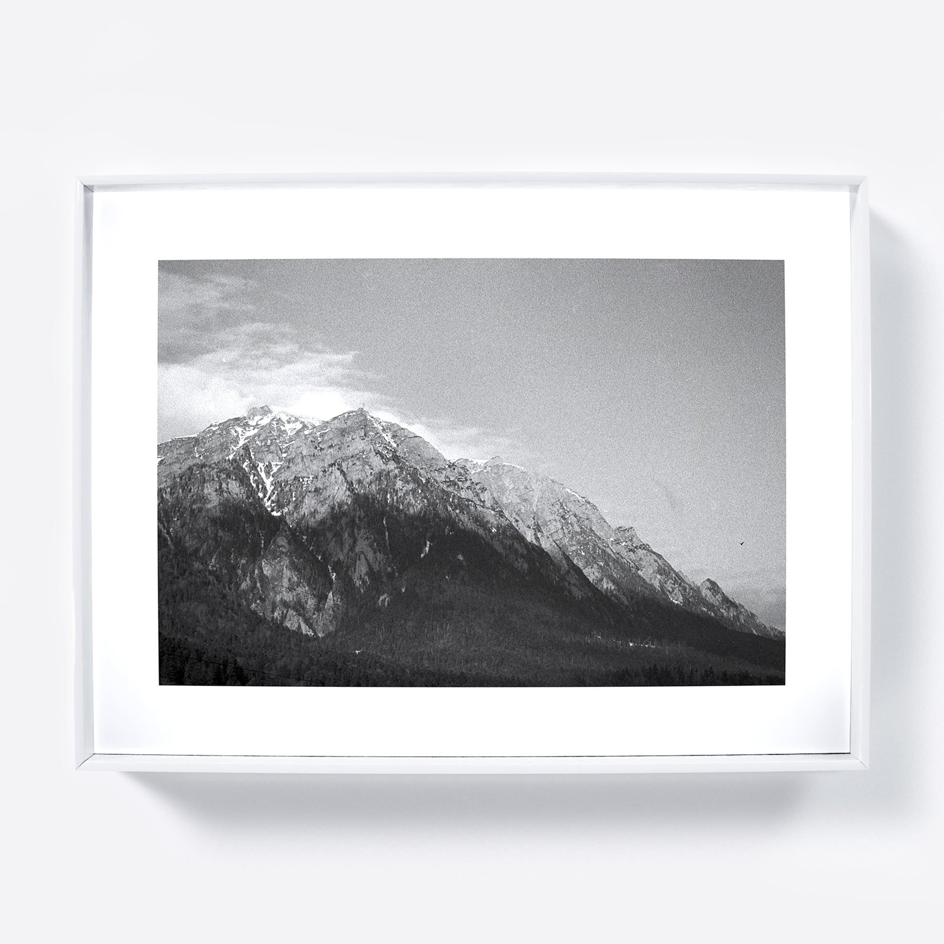 Framed black and white photograph of a mountain range with snow-capped peaks.