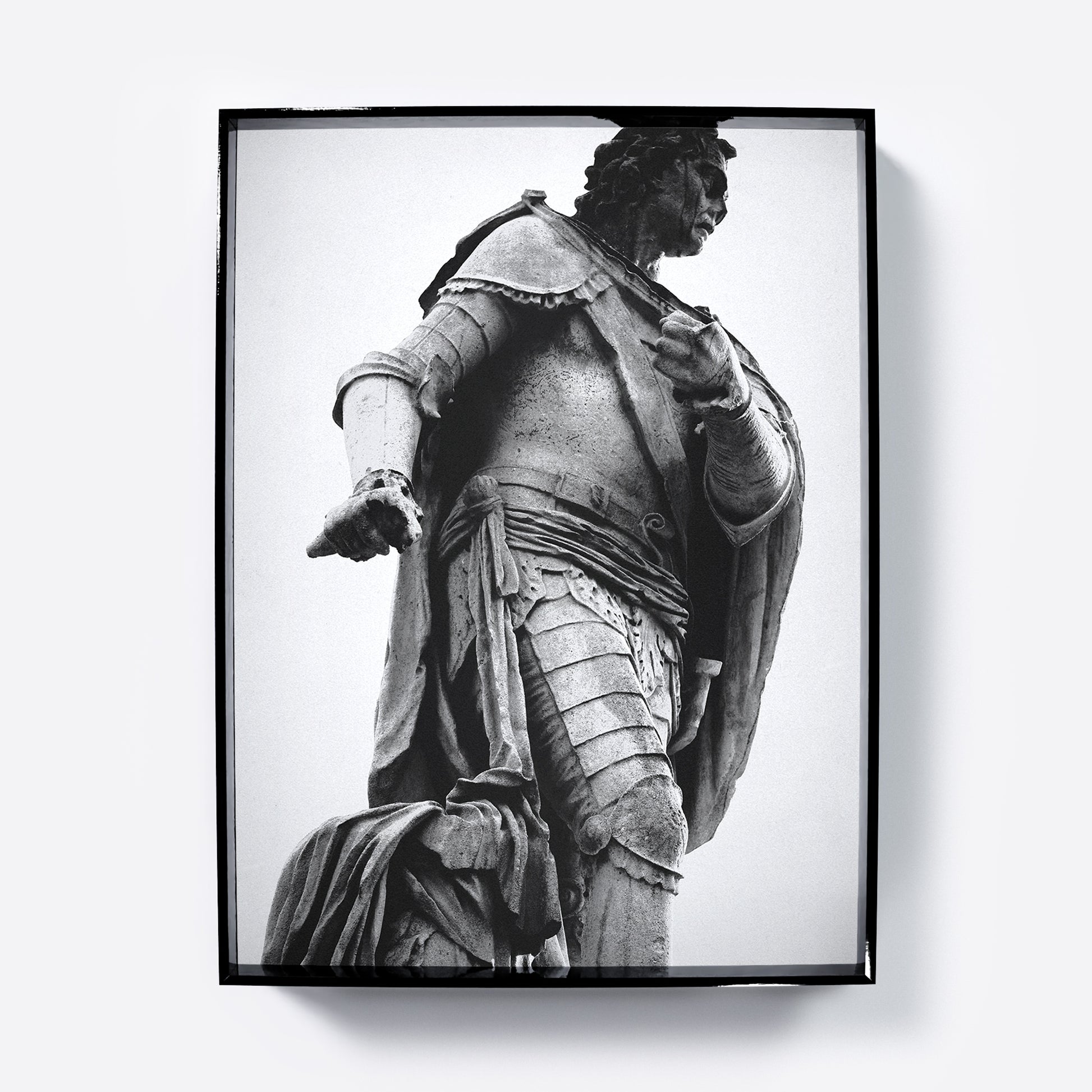 Framed black and white photography art print with a statue of a historical figure in armor against a light gray background.