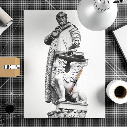 Black and white photography print with a statue on a white background, surrounded by stationery items.